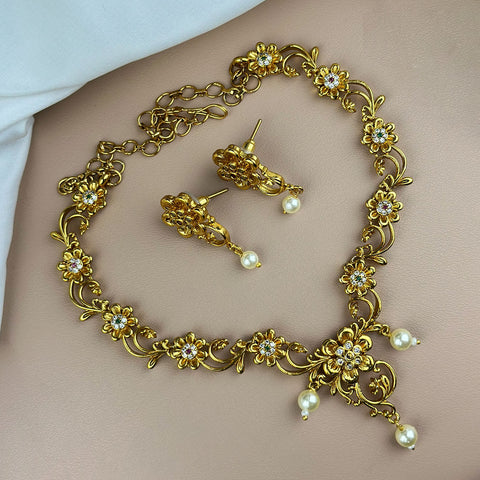 Gold necklace and earrings on a person's neck and chest.