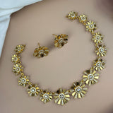 Gold necklace and earrings set on a plain background