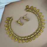 Gold necklace and earrings on a plain background