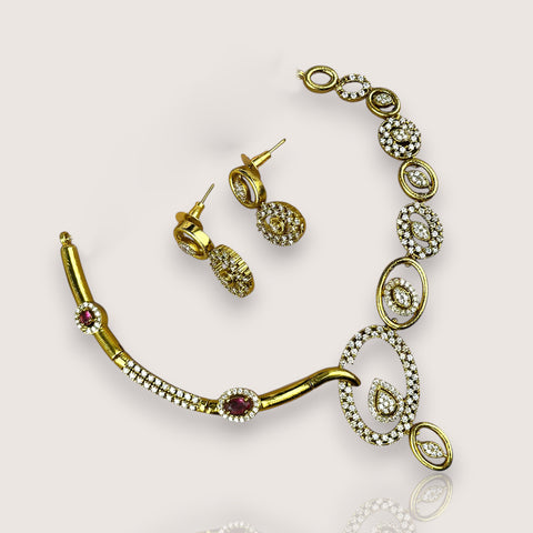 Gold necklace and earrings on a light background