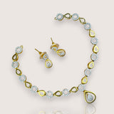 Gold necklace and earrings set on a light gray background