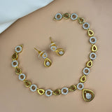 Gold necklace and earrings set on a beige surface