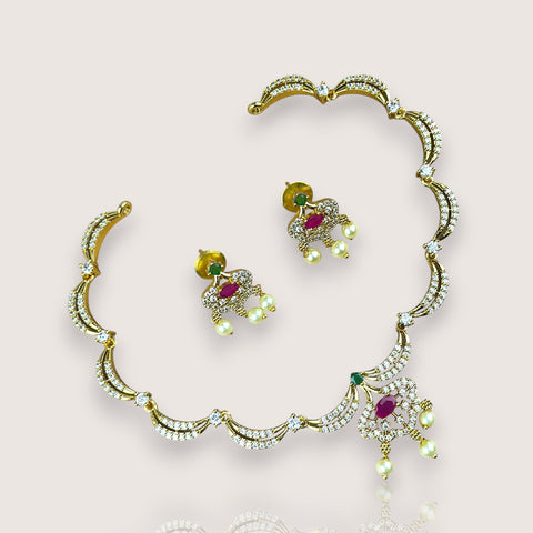 Gold necklace and earrings set on a plain background