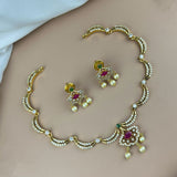 Gold necklace and earrings set on a plain background