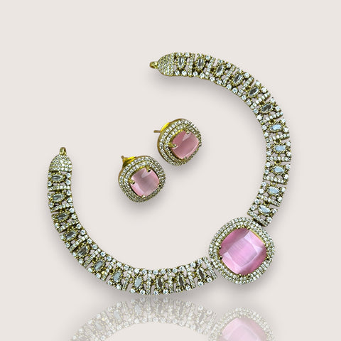 Necklace and earrings set with pink gemstones on a light background