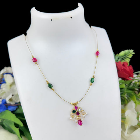 Necklace with colorful beads and a pendant on a white mannequin bust with flowers in the background