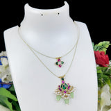 Two necklaces on a white mannequin with a floral background