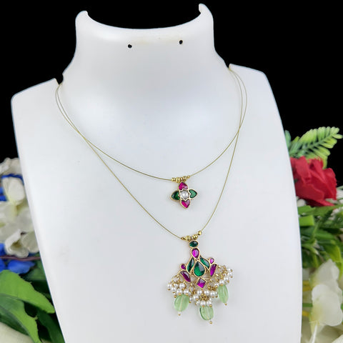 Two necklaces on a white mannequin with a floral background
