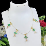 Gold necklace with green gemstones on a white mannequin bust against a floral background