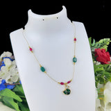 Necklace with green and red beads on a white mannequin bust with flowers in the background