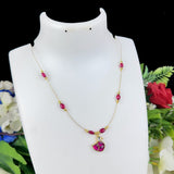 Necklace with pink beads and a heart-shaped pendant on a white mannequin bust with floral background