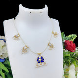 Gold necklace with a blue pendant on a white mannequin bust, surrounded by flowers.
