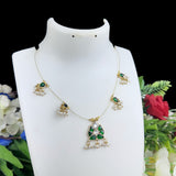 Gold necklace with green gemstones on a white mannequin bust against a floral background