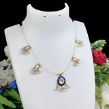 Delicate necklace with blue and gold pendant on a white mannequin bust against a floral background