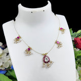 Gold necklace with pink and clear gemstones on a white mannequin against a floral background