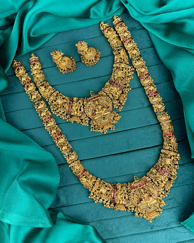 Gold necklace and earrings on a teal fabric background