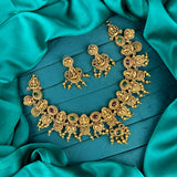 Gold necklace and earrings on a teal fabric background