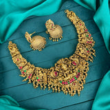 Gold necklace and earrings on a teal fabric background