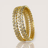Gold bracelet with clear stones on a light gray background