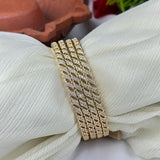 Gold bracelet with diamond accents on a white fabric background
