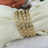 Gold bracelet with diamond accents on a white fabric background