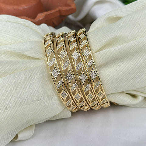 Gold bracelet with diamond accents on a white fabric background