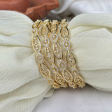 Gold bracelet with diamond accents on a white fabric background