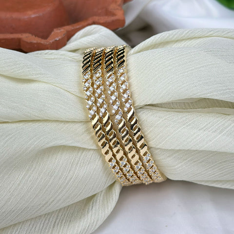 Gold bracelet with diamond accents on a white fabric background