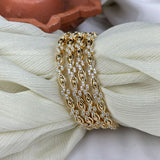 Gold bracelet with diamonds on a textured white surface