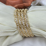 Gold bracelet with diamond accents on a white fabric background