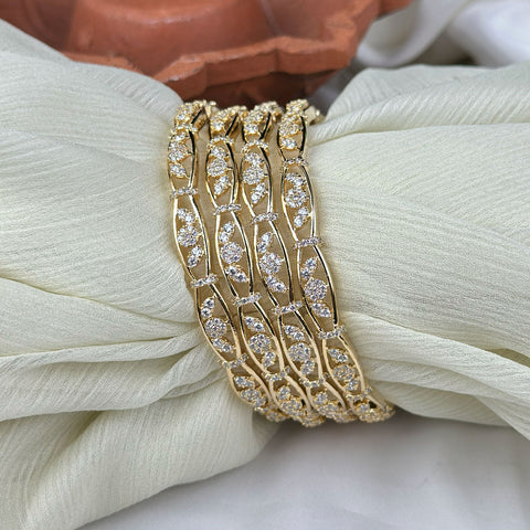 Gold bracelet with diamond accents on a white fabric background
