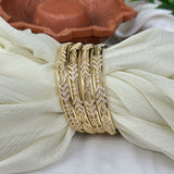 Gold bracelet with diamond accents on a white fabric background
