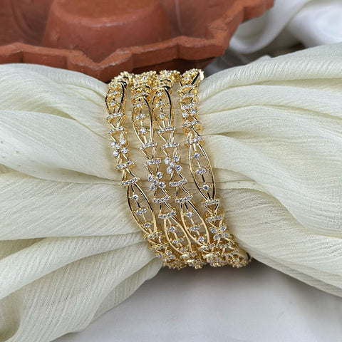Gold bracelet with diamond accents on a white fabric background