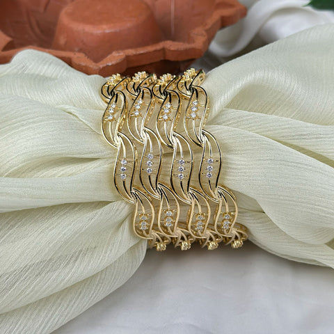 Gold bracelet with diamond accents on a white fabric background