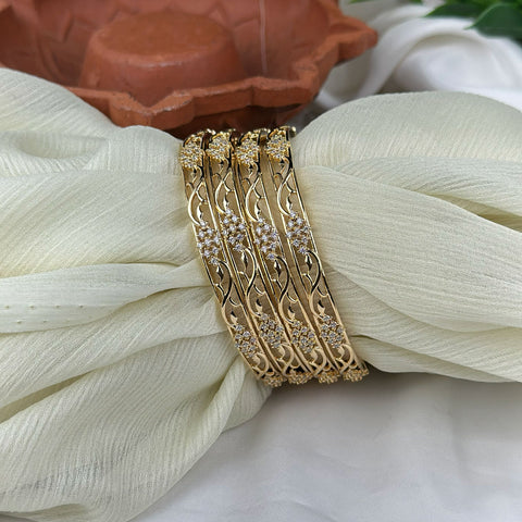 Gold bracelet with diamond accents on a white fabric background