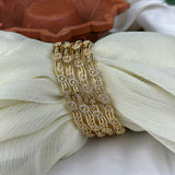 Gold bracelet with diamond accents on a white fabric background