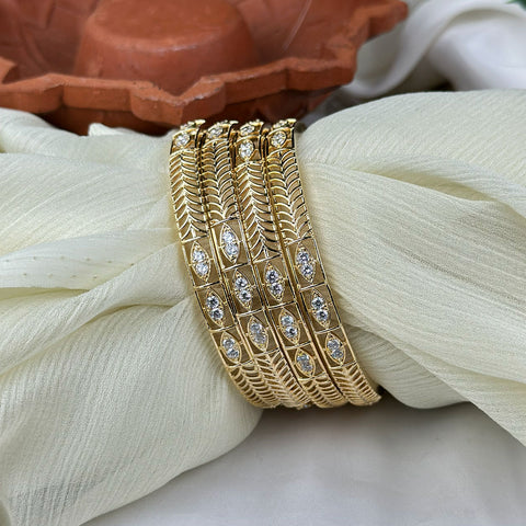 Gold bracelet with diamond accents on a white fabric background