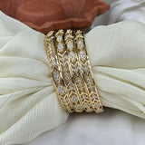Gold bracelet with diamond accents on a white fabric background