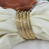 Gold bracelet with diamond accents on a white fabric background