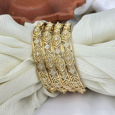 Gold bracelet with diamond accents on a white fabric background