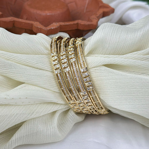 Gold bracelet with diamond accents on a white fabric background