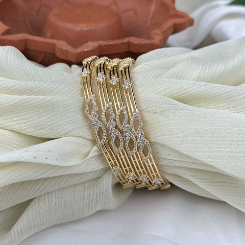 Gold bracelet with diamond accents on a white fabric background