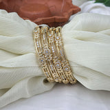 Gold bracelet with diamond accents on a white fabric background