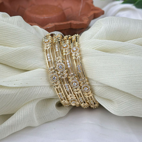 Gold bracelet with diamond accents on a white fabric background