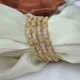 Gold bracelet with diamond accents on a white fabric background