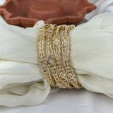 Gold bracelet with diamond accents on a white fabric background