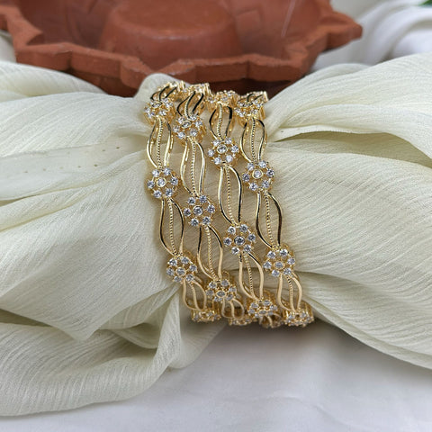 Gold bracelet with diamond accents on a white fabric background