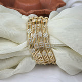 Gold bracelet with diamond accents on a white fabric background