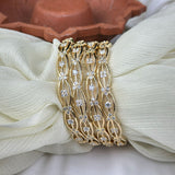 Gold bracelet with diamond accents on a white fabric background
