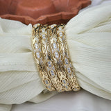 Gold bracelet with diamond accents on a white fabric background